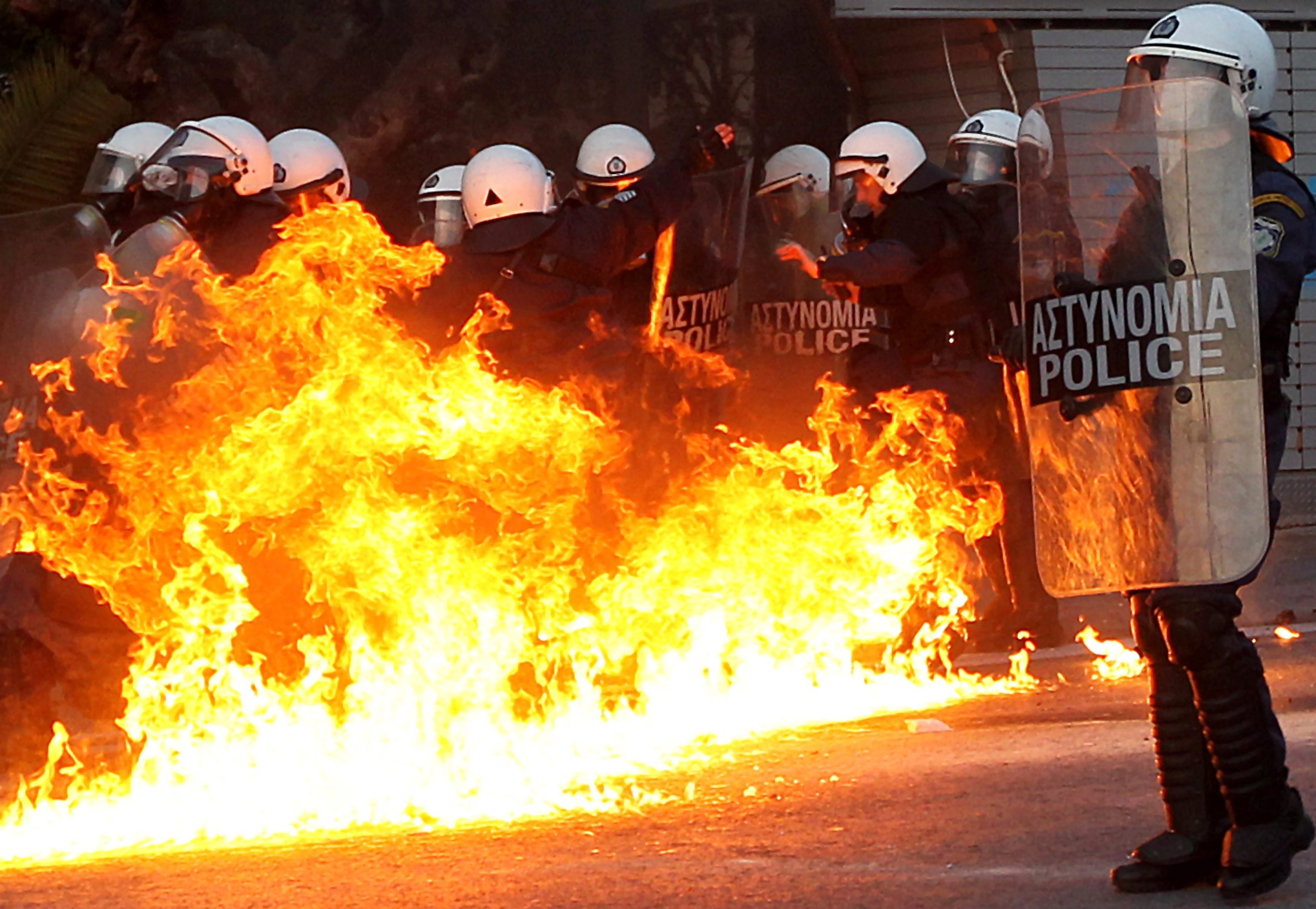 epa03102933 Protesters clash with riot police outside of the Greek Parliament in Athens, Greece, 12 February 2012. Greece’s parliament is to decide on whether to approve the new round of austerity measures that will allow the country facing bankruptcy to qualify for a second international bailout.  EPA/ORESTIS PANAGIOTOU