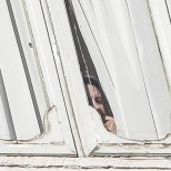 Il premier Matteo Renzi dietro la tenda della finestra del suo studio a Palazzo Chigi (Ansa)